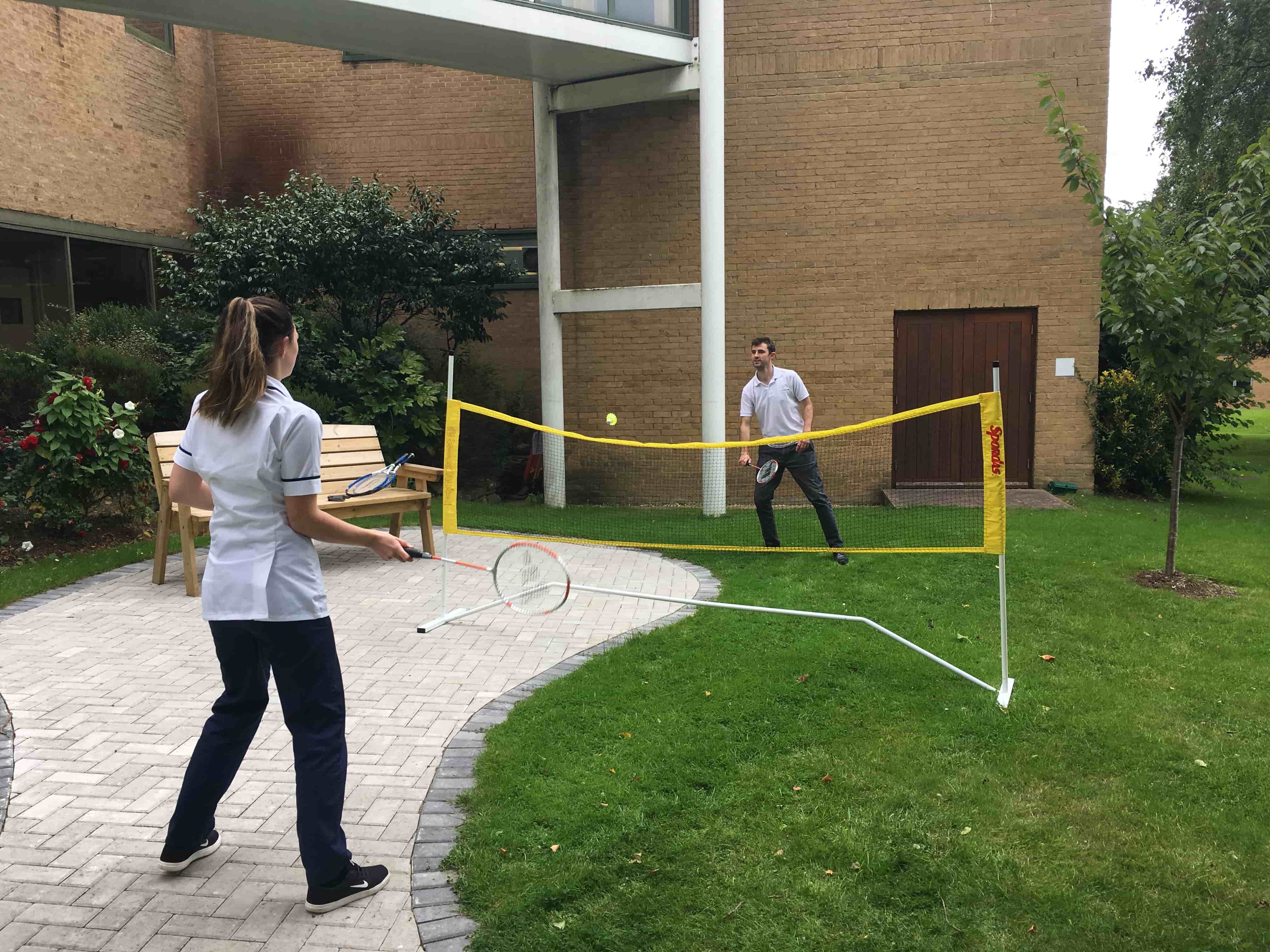 Staff playing badminton in hospital grounds