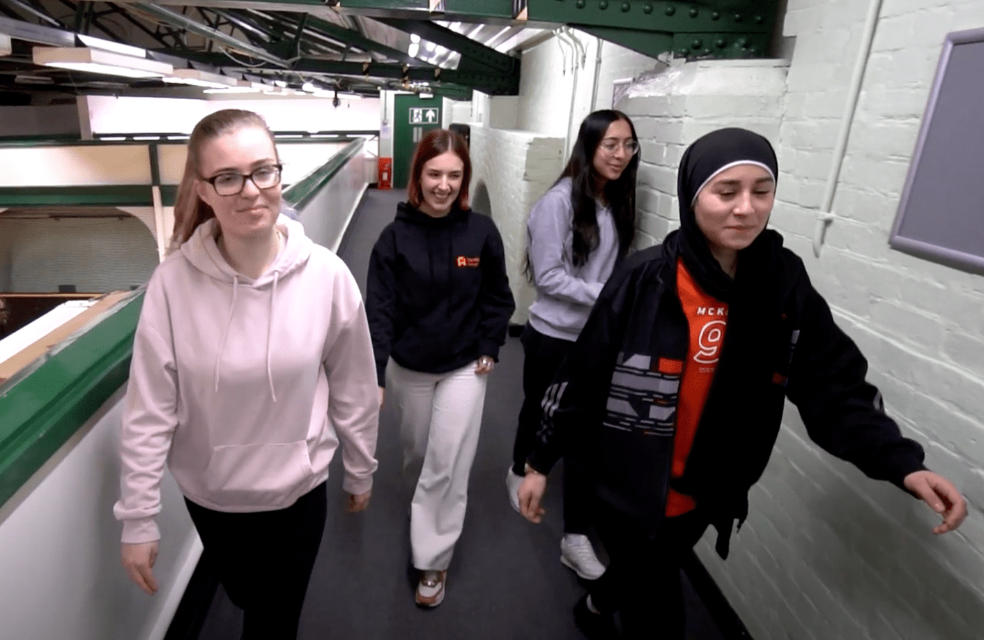 4 female teenagers walking in a hallway 