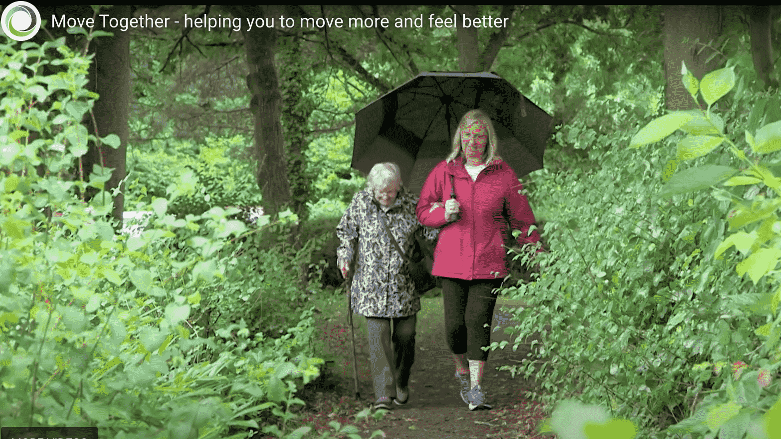 96 year old Majorie enjoying a walk in woods with another female working.