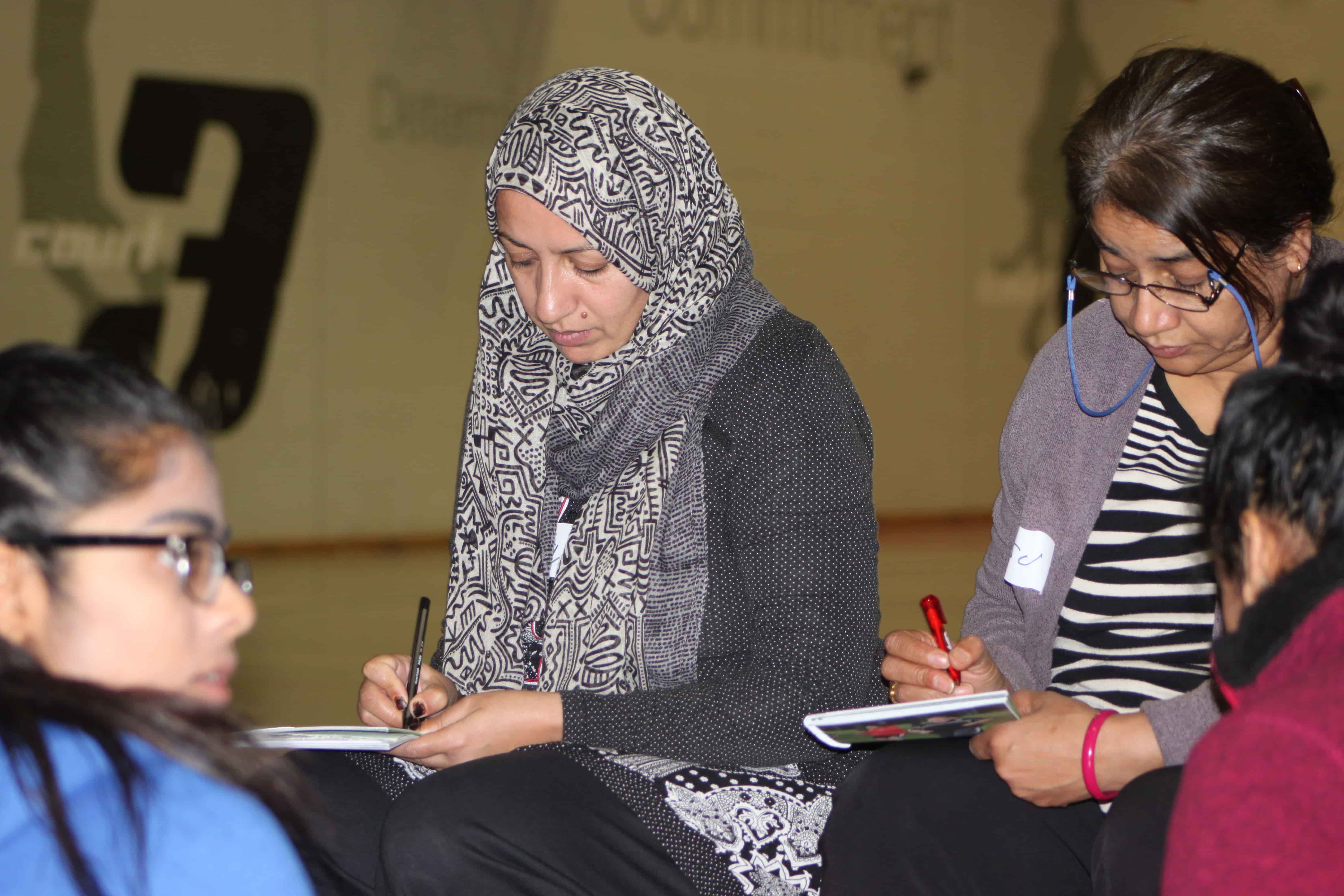 Muslim Women taking notes during course