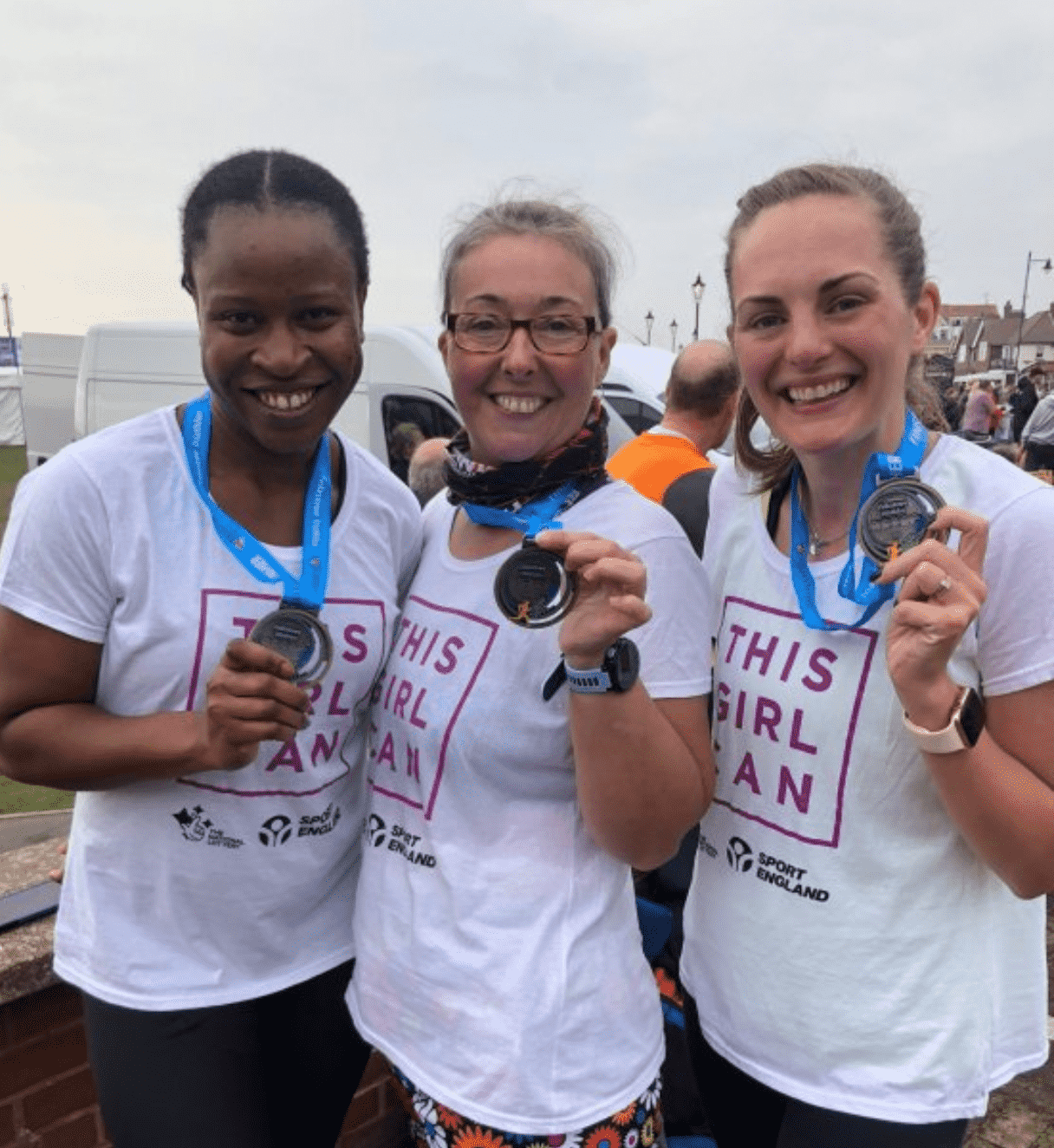 Emma, Damilola and Louise wearing This Girl Can t-shirts and medals 