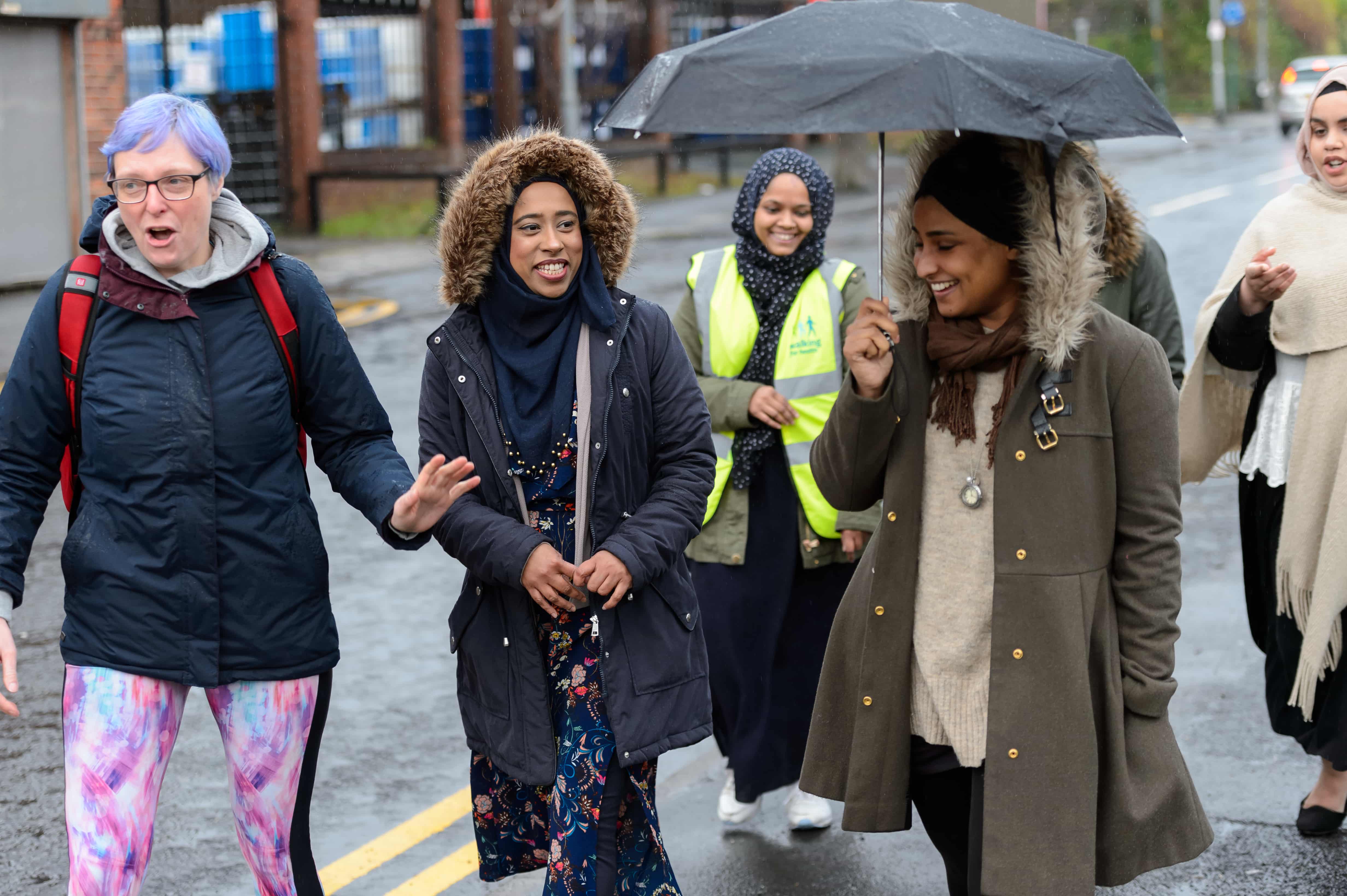 Group of women enjoying a walk in the rain