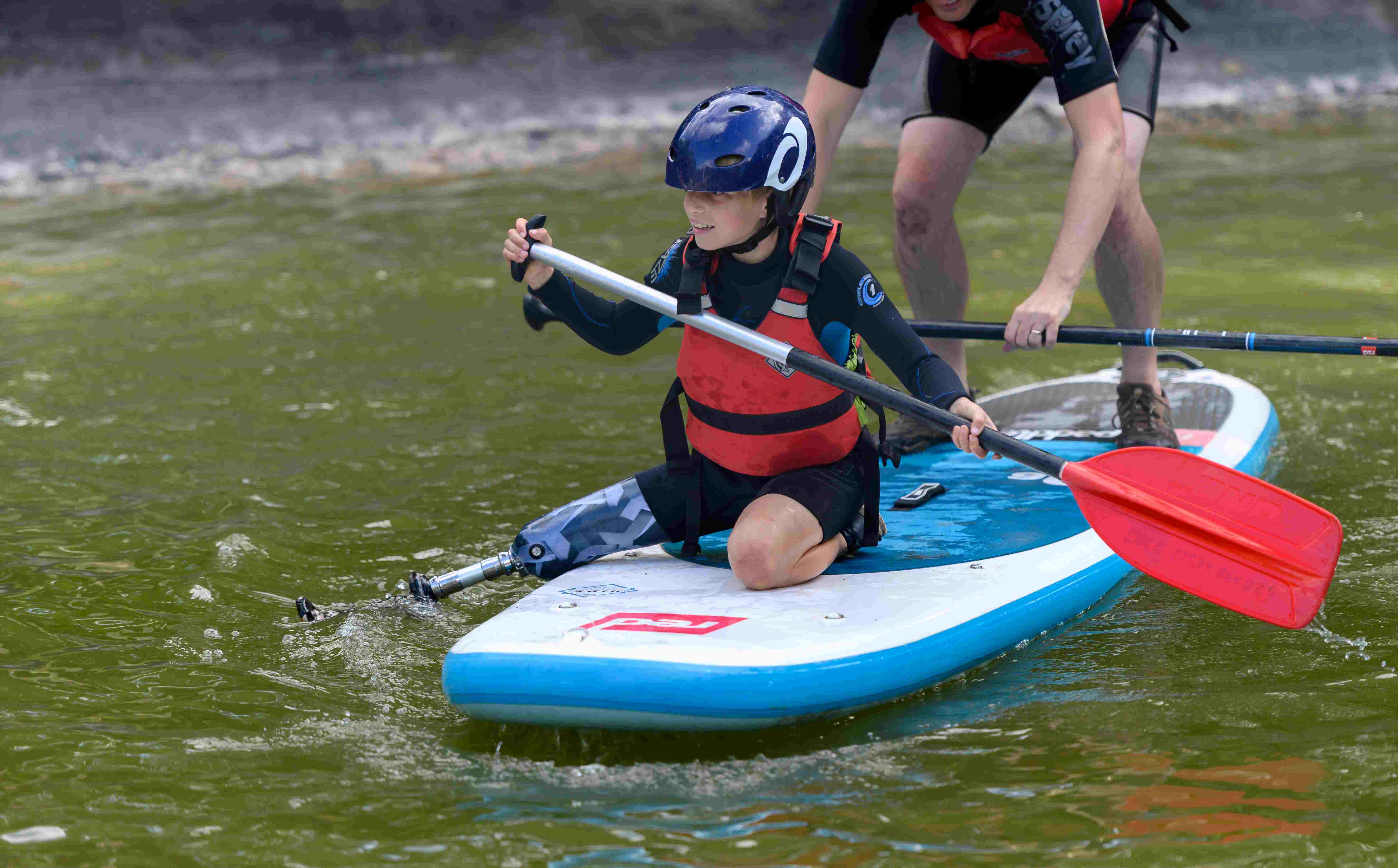 A young person with a disability tries paddleboarding 