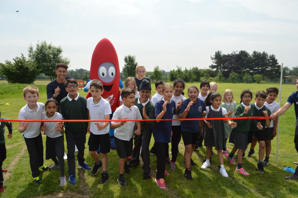 Group of school children and Mascot Zoom cutting ribbon at the launch