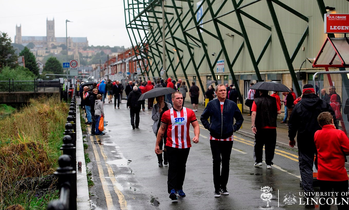 supporters walking by a football stadium 
