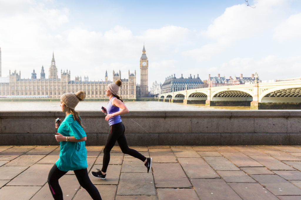 two people running along the embankment in London