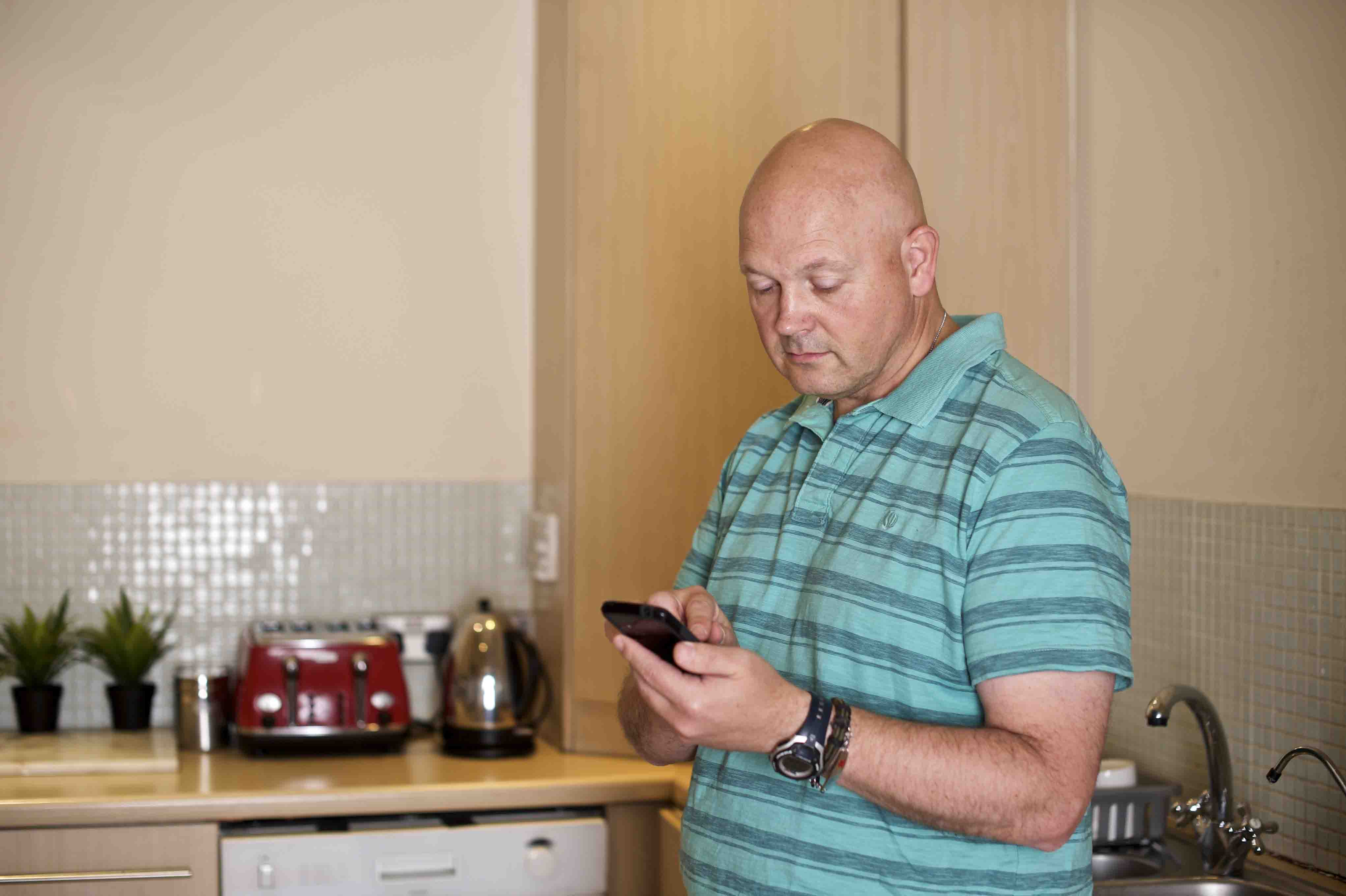man on his mobile phone in the kitchen