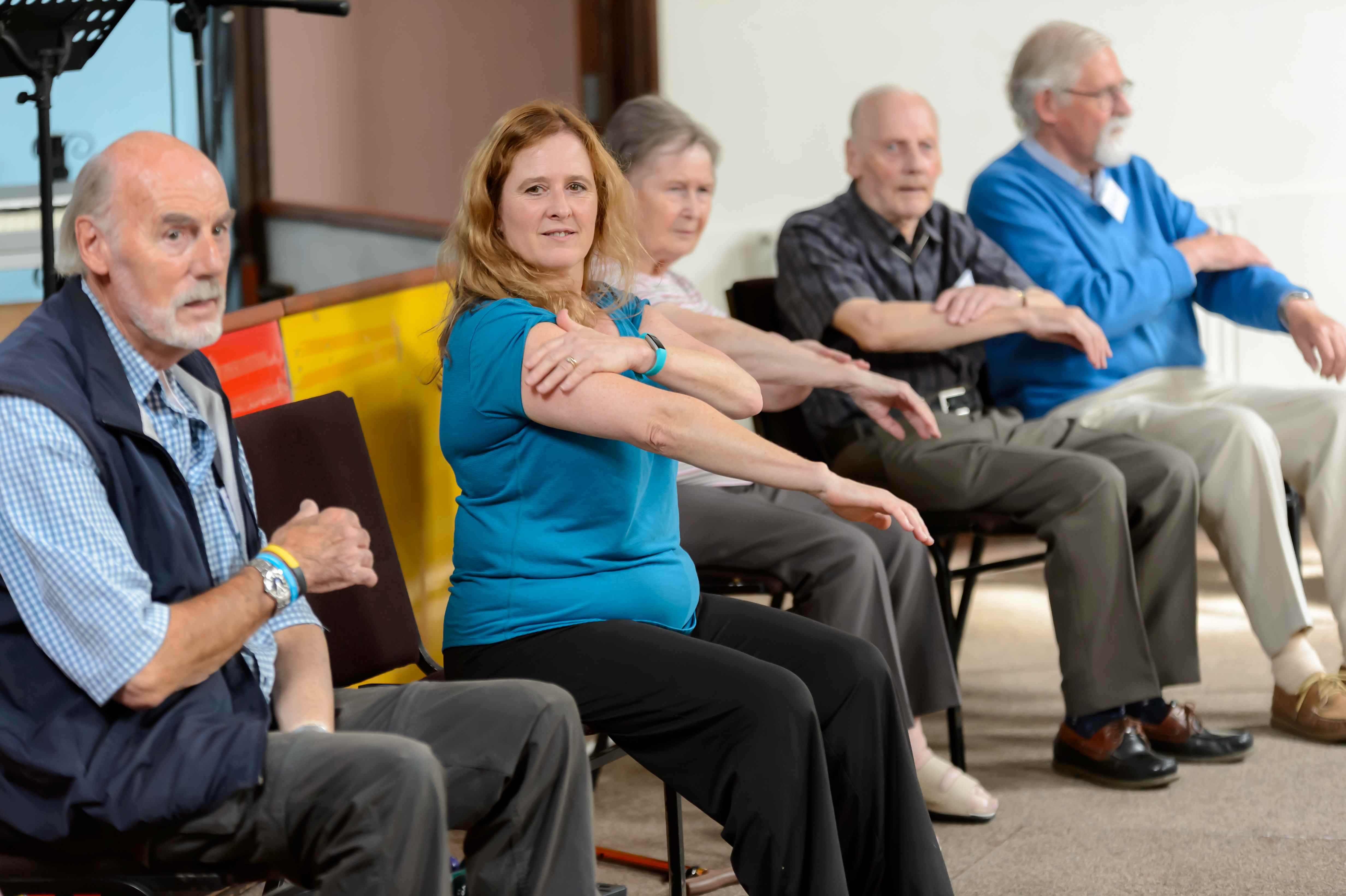 A fitness instructor leads a group session for older adults 