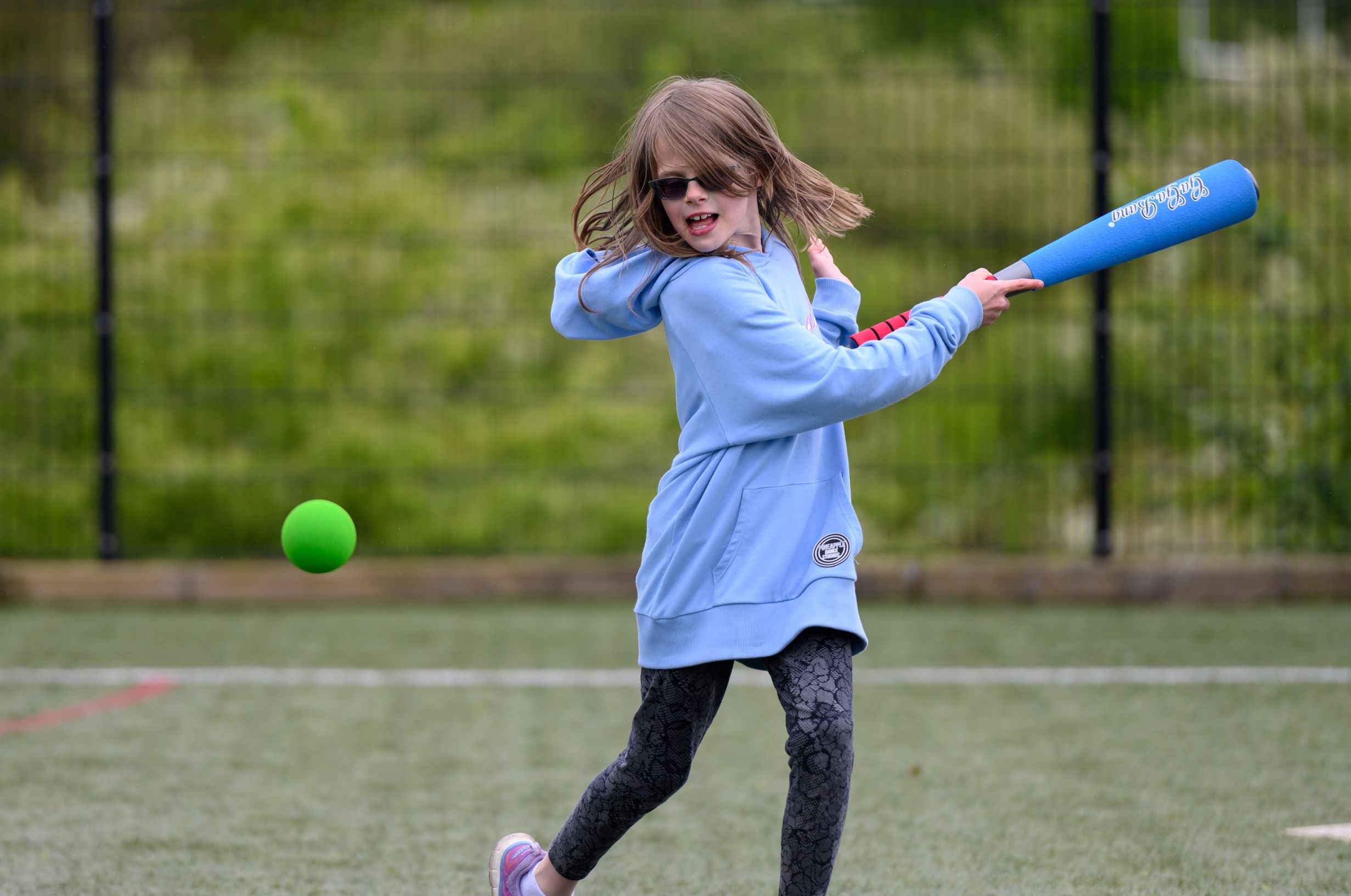 Girl playing rounders at multi sport facility