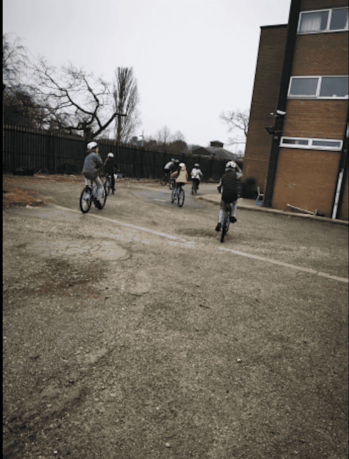 4 young people on bikes riding around a housing estate