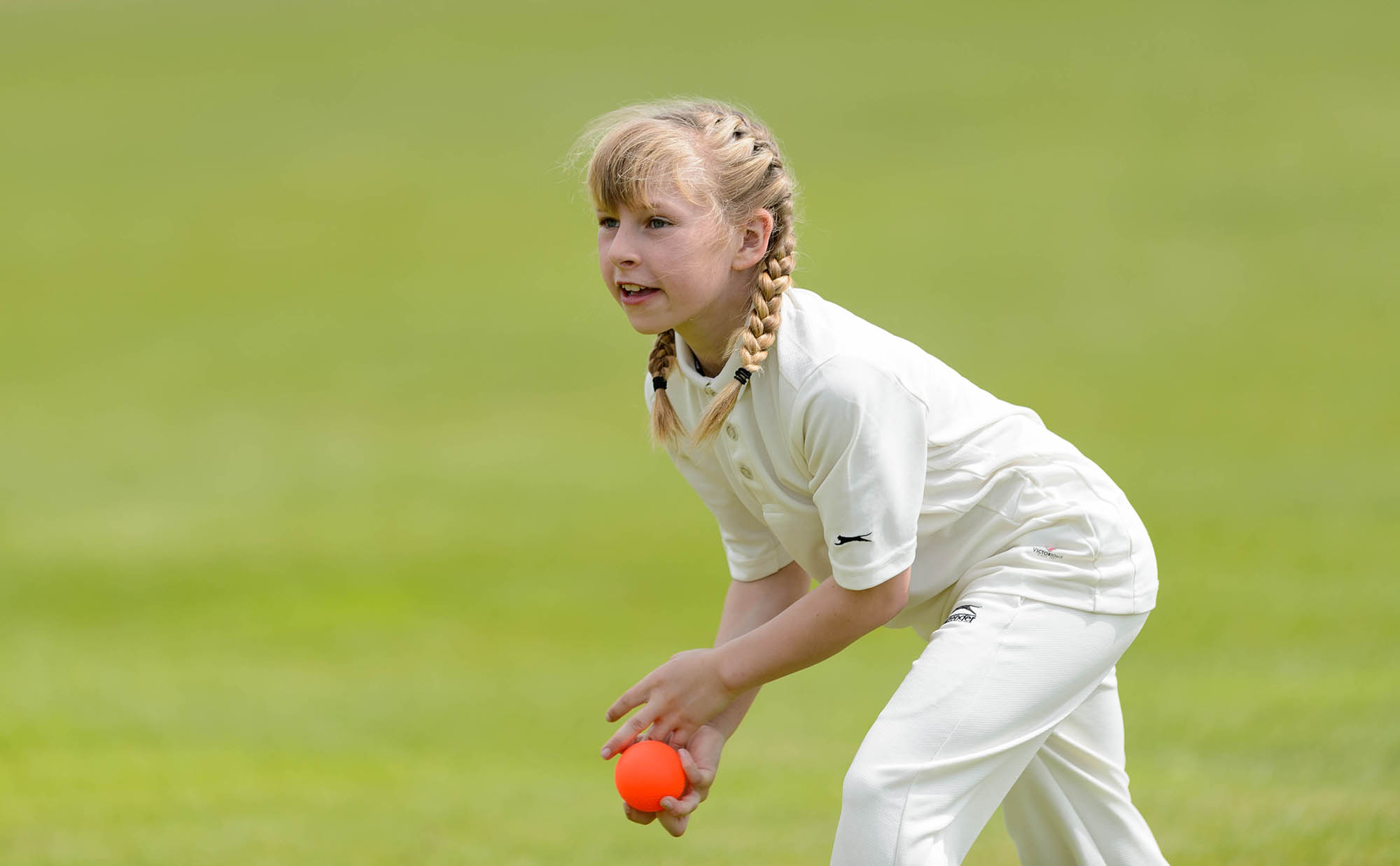 young girl throwing cricket ball