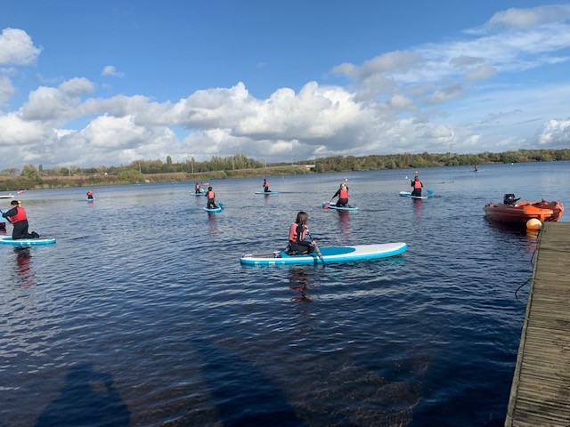 group of young people paddling boarding on a sunny day