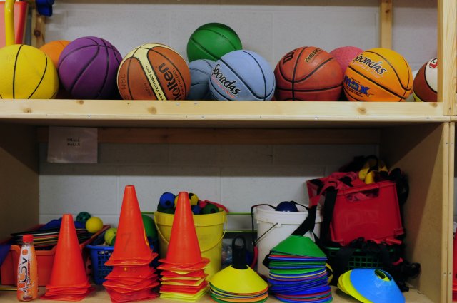 diffrent coloured sports equipment in a cupboard 