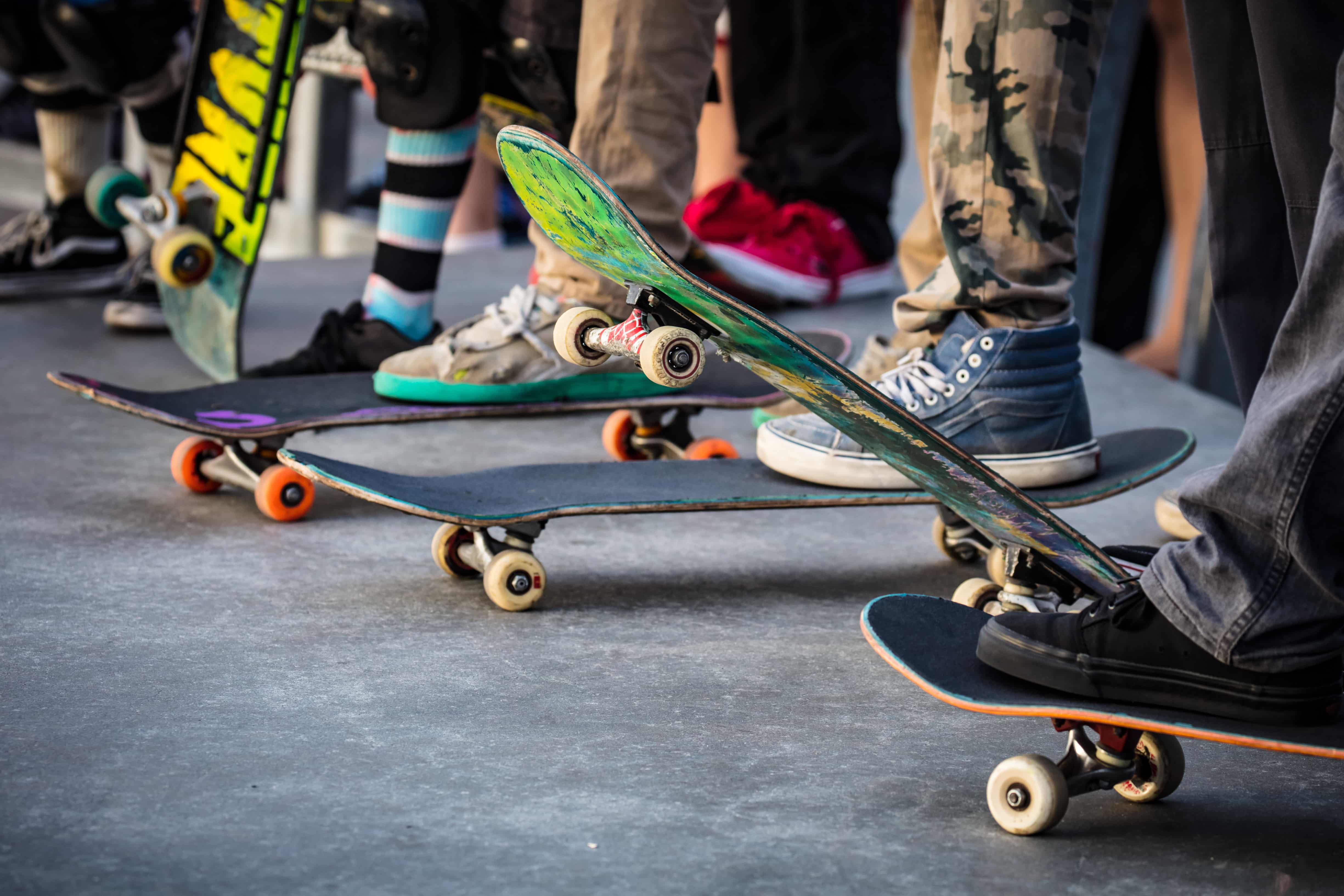 row of feet on skateboards 