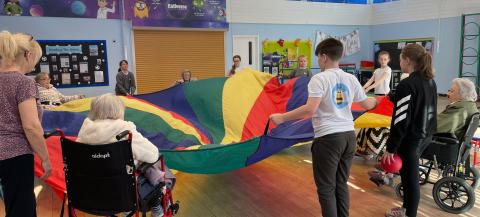 Photo of children and care home residents being active together