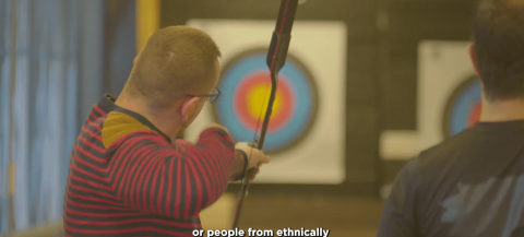 person shooting an archery arrow at a target