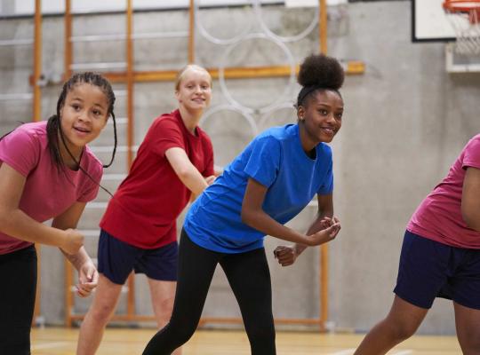girls doing a dance class in a sports hall