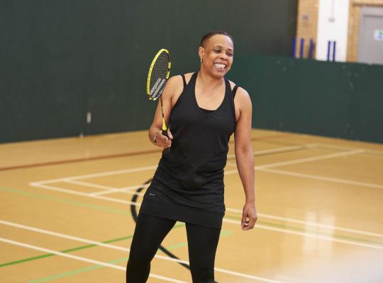 Female playing badminton in a sports hall 