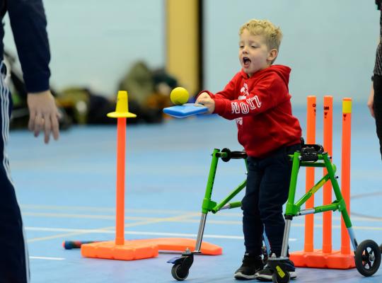 young disabled boy playing indoor cricket