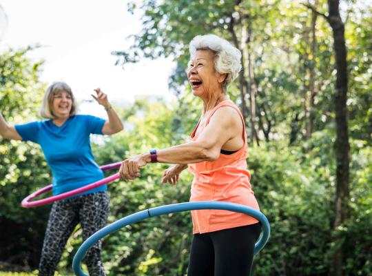 older women hula hooping in park