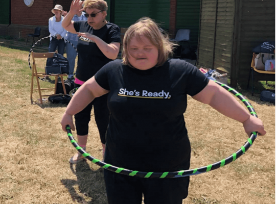Female hula hooping in an outdoor space 