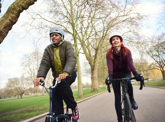 man and women cycling through a park