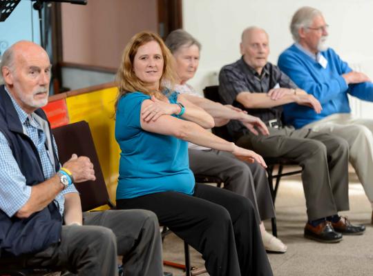A fitness instructor leads a group session for older adults 
